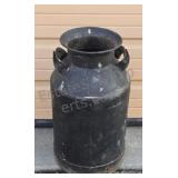 Steel milk can painted black. Some small rust