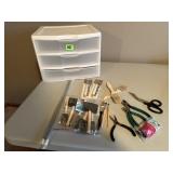 Storage bin, paint brushes, wire cutters,