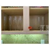 Shelf of drinkware, champagne flutes, sherry