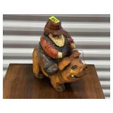 Farmer riding pig wood carving