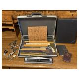 Briefcase of rulers, hole punches, office supplies