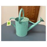Green metal watering can