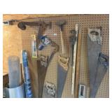 Contents of pegboard, hand saws, tape dispenser,