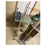 Bucket of garden tools, rake, hoes, watering can
