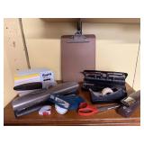 Office supplies, paper punches, clipboard, tape