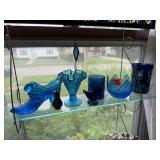 Shelf of blue glassware, shoe, votive holders