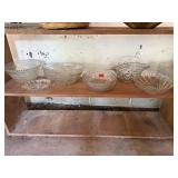 Shelf of glass serving bowls, relish trays,