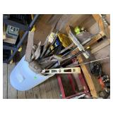 Barrel of tools, shovels, rake, level, axe