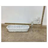 Two clear glass candle holders in white basket
