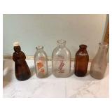 Antique glass milk bottles and Aunt Jemima syrup bottle
