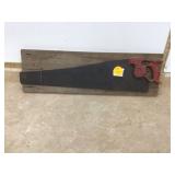 Antique handsaw mounted on rustic barn wood