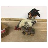 Rooster staring at snail figurine