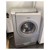 Front load washing machine with storage drawer