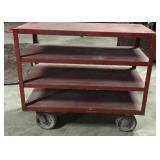 Red cart on wheels with miscellaneous , 4 shelf