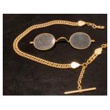 Heavy watch chain and gold rim glasses