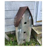 Bird House, primitive, sits on the ground