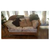 Rattan love seat with cushions and pillows