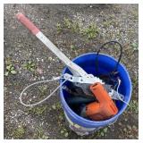 Bucket of tools including comealong, saw,