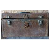 Rusted metal toolbox full of assorted tools