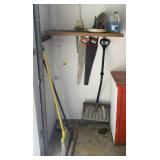 Contents of corner including brooms, shovel,