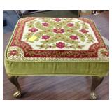 Upholstered foot stool with metal legs.