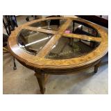 Round walnut coffee table with glass inserts.