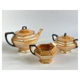 Orange and black lusterware teapot, pitcher, jar