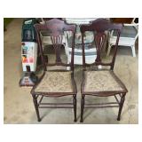 Pair of red wooden chairs with embroidered seats,