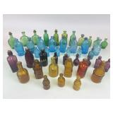 Mini elixer and bitters bottles, some with corks,