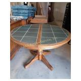 Circular wood dining table with green ceramic