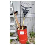 Red barrel with rake, mop, push broom, snow