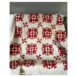 Hand stitched red and white quilt, stained