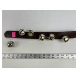 Sleigh on leather strap with one sleigh bell not