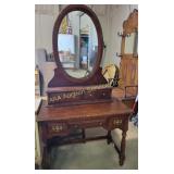 wooden vanity with a large oval mirror and three