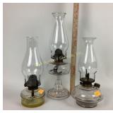 Clear glass oil lamps, with chimneys.
