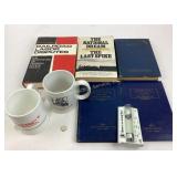 Railroad books and coffee mugs.  Books of coins