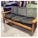 Wood frame three-seat sofa with green cushions