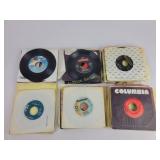 Assorted 45 RPM vinyl records with sleeves