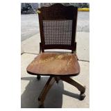 Swivel desk chair with ornate & cane back. Roller