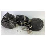 Three Black Canvas Drawstring Bags Filled With San
