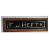 F.J. Hefty framed sign, glass cracked, 8 1/2x28"