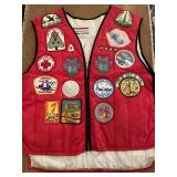 Red vest size medium full of old badges and pins.