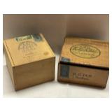 Two vintage cigar boxes. One of the boxes is by H