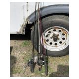 Three fishing poles with reels, one is an open