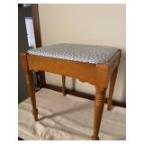 Small wooden bench with padded seat. Measures 17
