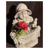 Statue of a little girl hon flowers with a bird
