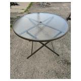 Outdoor glass top table holds umbrella 
Screw