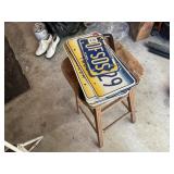 Old license plates and a stool, most are