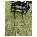 Hydraulic adjust skid loader forks