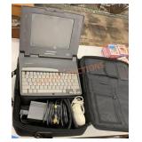 Vintage Compaq laptop with cords and accessories